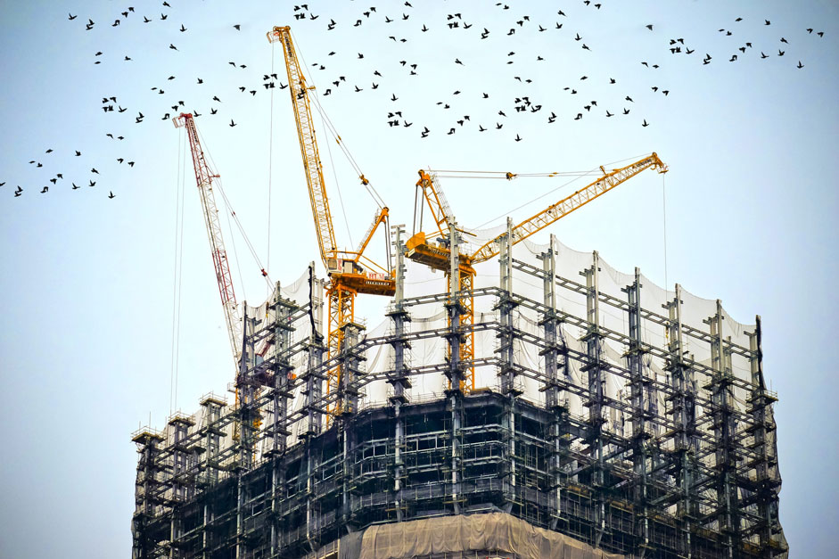 Building under construction with cranes on the top
