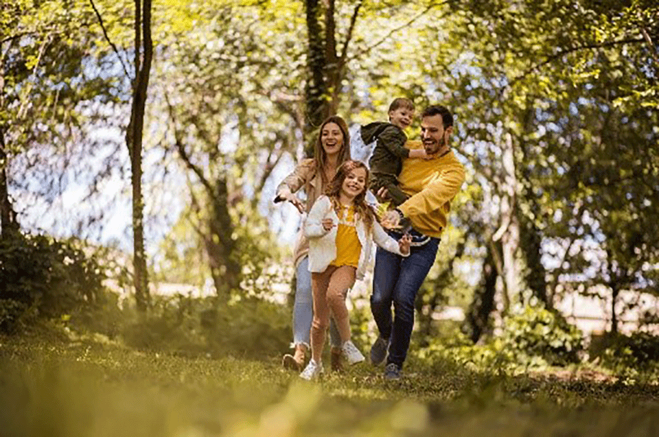 Parents walking with their young children in a green park