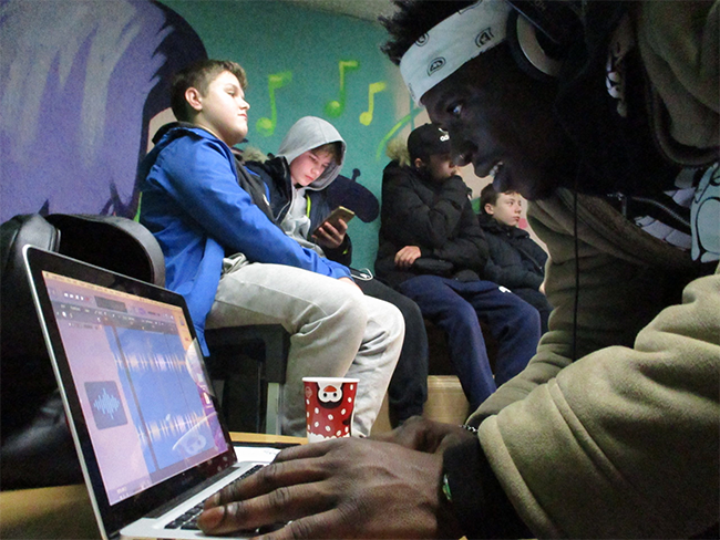 A young man editing music on his computer