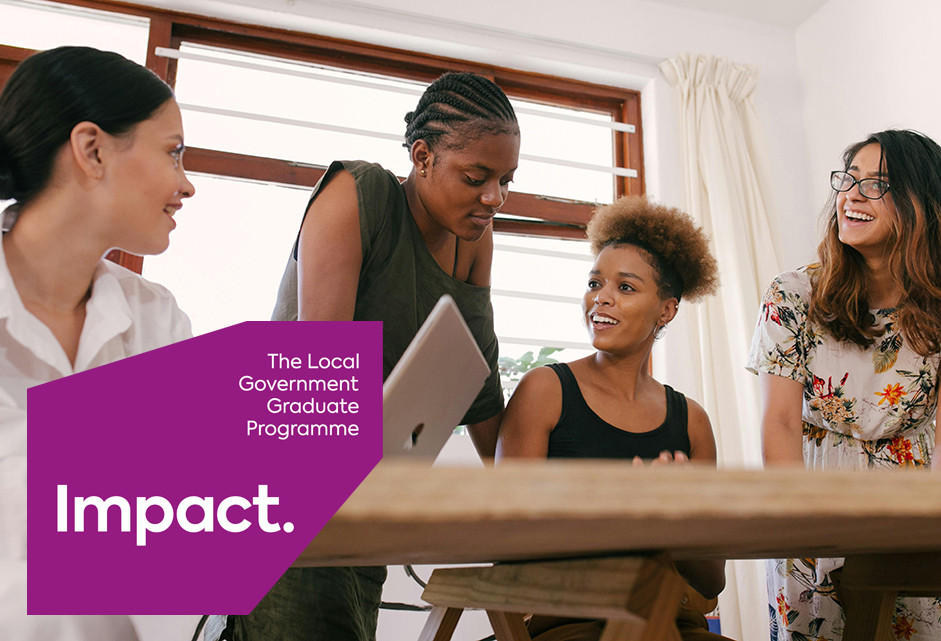 a diverse group of young women siting on a table and talking about a project