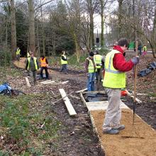 Volunteers in park repairing decking footpath
