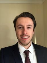 Joe Siggins in a suit smiling at the camera