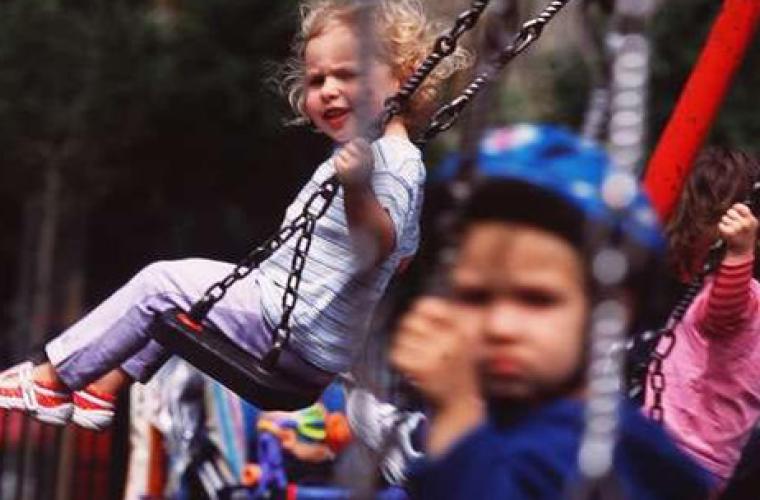 Two toddlers on a swing