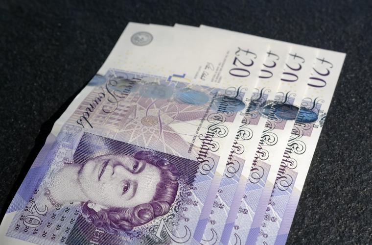 Four £20 notes on a table