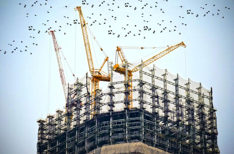 Building under construction with cranes on the top
