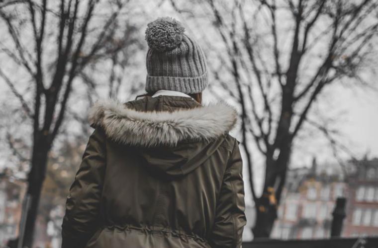 Girl in a winter coat with her back to the camera