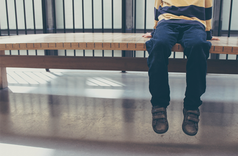 Young boy sat on a bench in a museum
