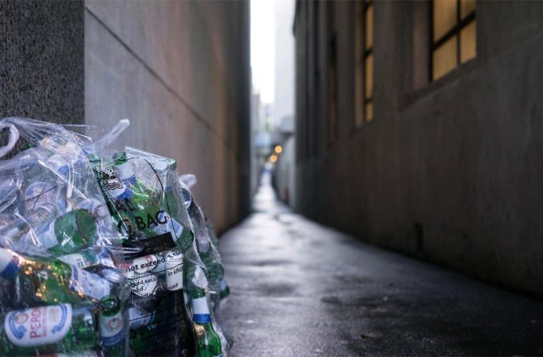 Photo of empty glass bottles in clear recycling bag