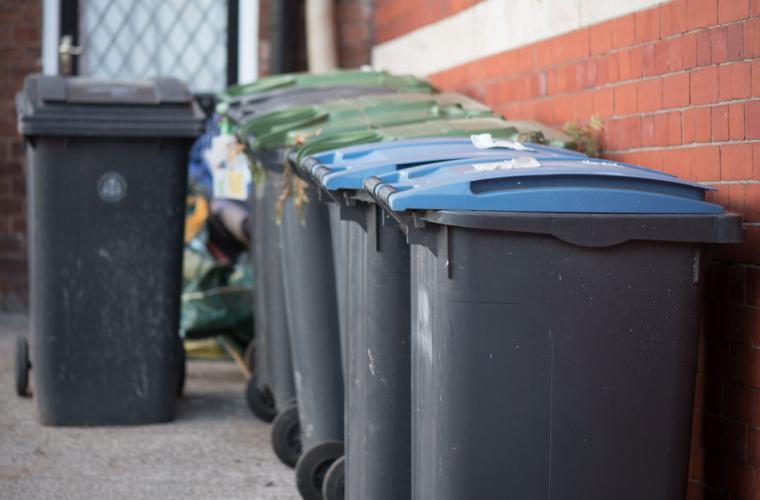 Row of bins by a red brick wall