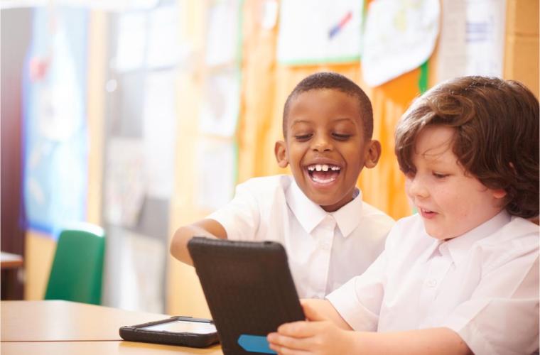 School children playing on ipad