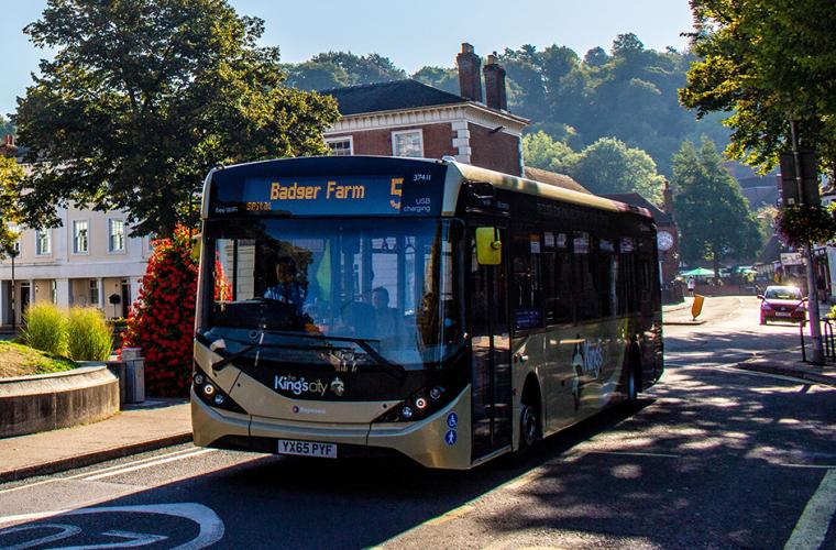 Public bus being driven on the streets of Winchester on a sunny day