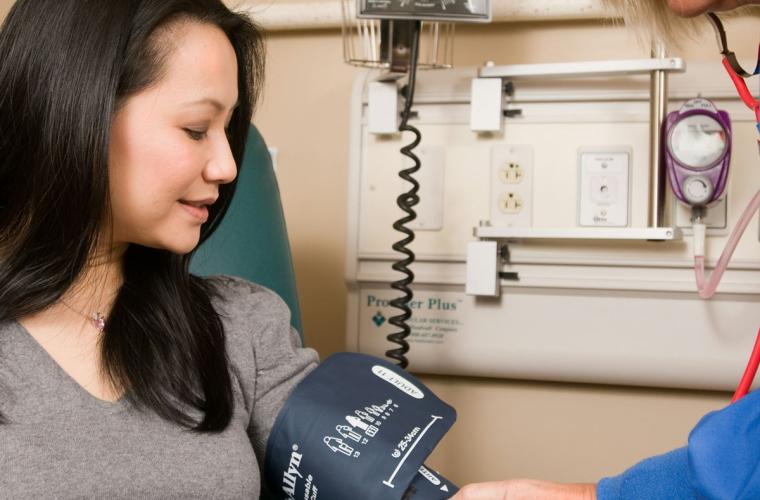 Woman having her blood pressure taken by a nurse