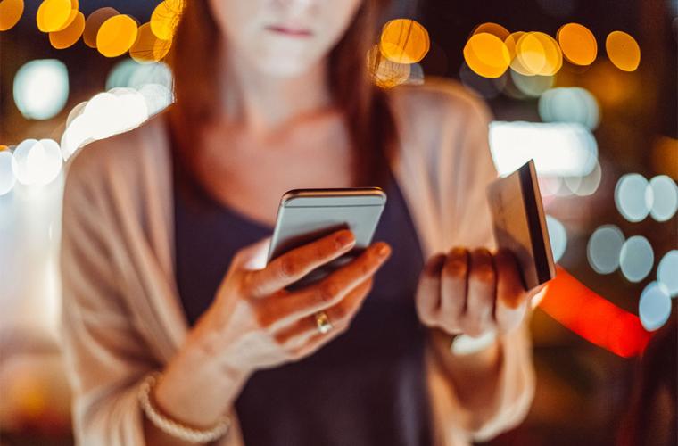 A woman paying for something on her phone with her credit card