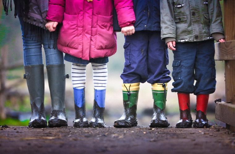 Row of children's legs in wellington boots