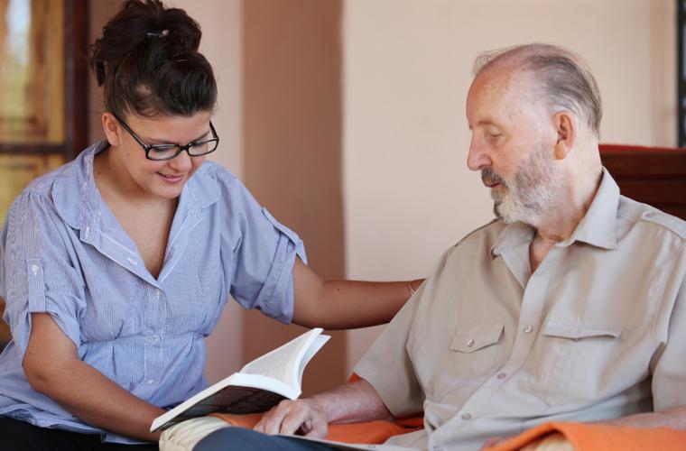 Carer reading to an older man