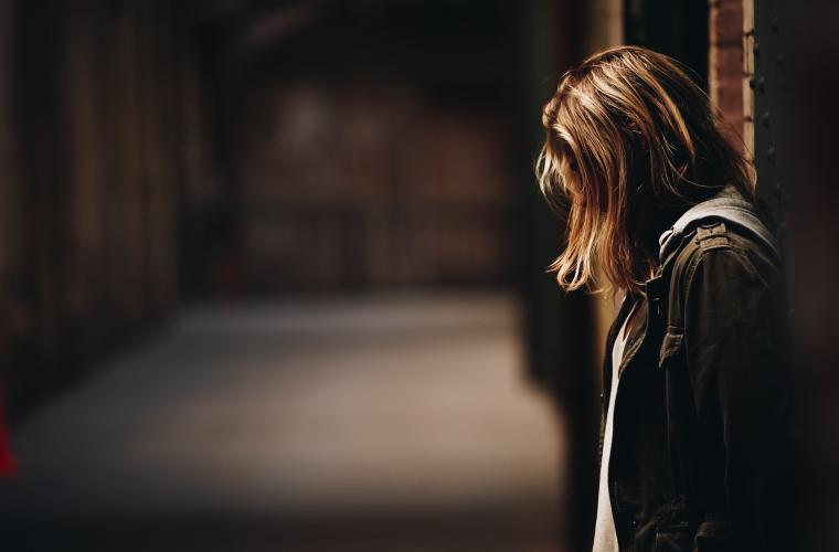 Woman in a sheltered underpass standing alone