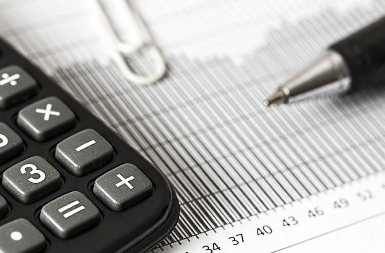 Calculator and a pen resting on some documents 
