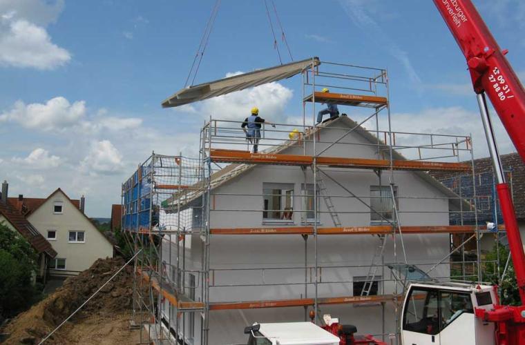 crane putting new roof on a house