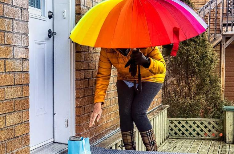 lady with bright umbrella delivering a food parcel