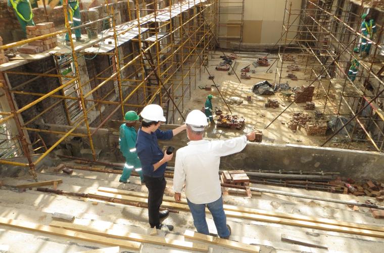 Two men with hard hats on discussing where to build next