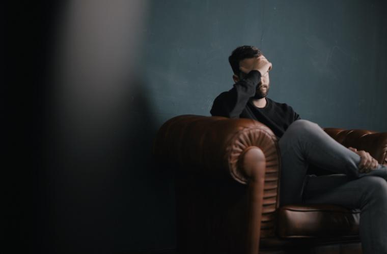 man sat in a chair looking stressed