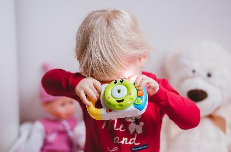 Child covering face with a toy