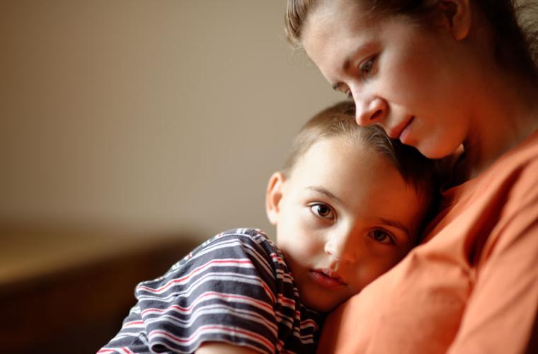 Young boy sitting on lady's knee