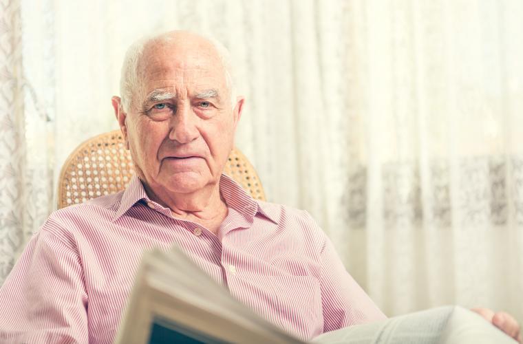 Older man, sat in a chair at home