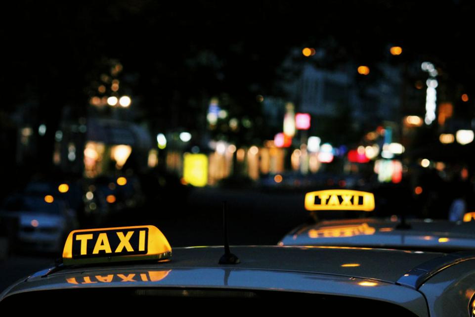 Taxis at night with light of city in the background