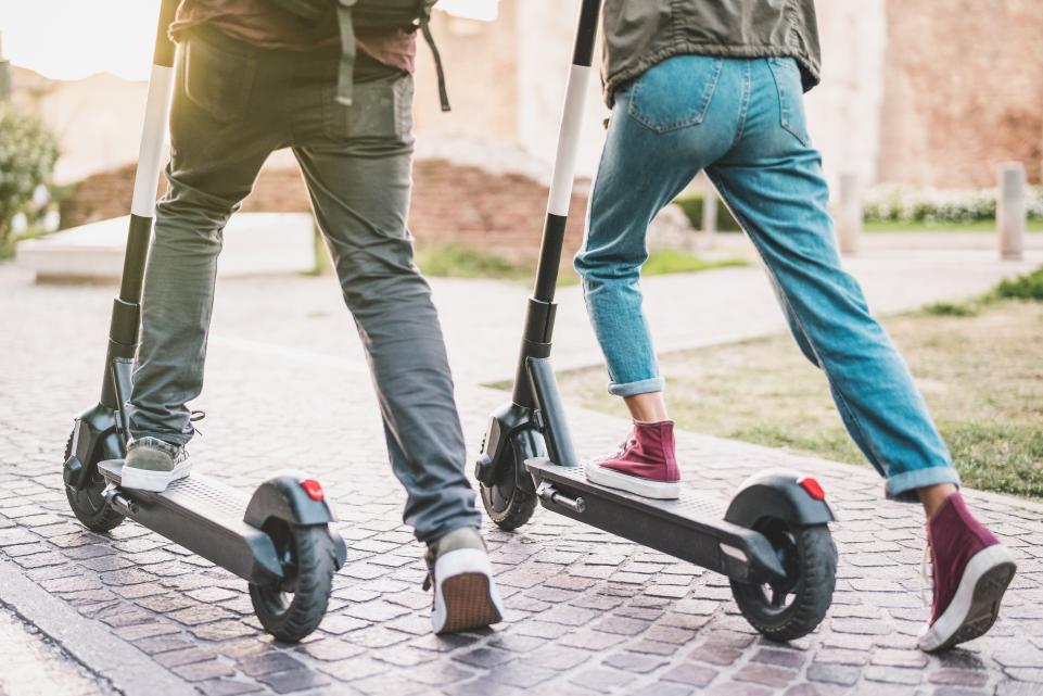 two people cycling on e scooters